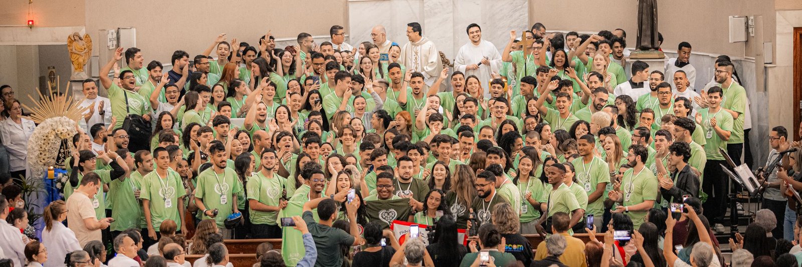 Igreja lotada de jovens missionários com os padres no altar